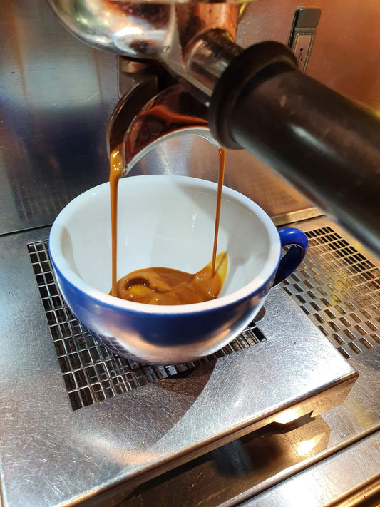 coffee extract pouring from the coffee machine to a mug