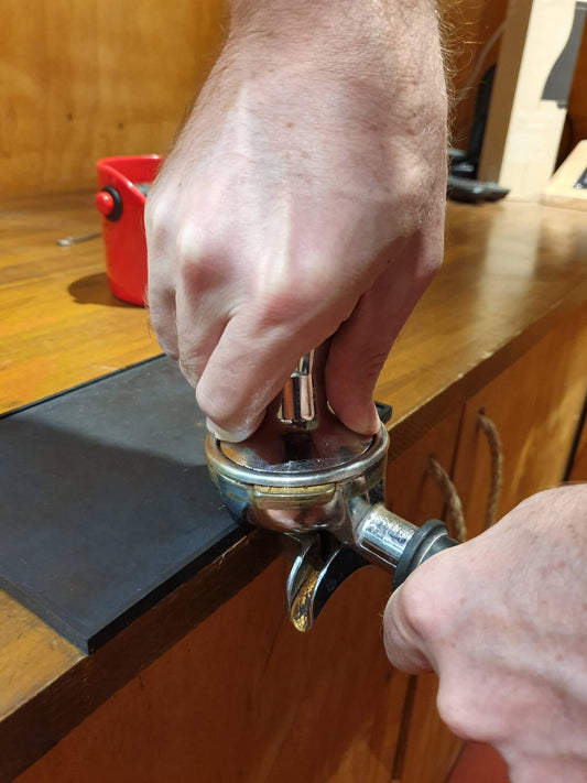 process of tamping coffee beans