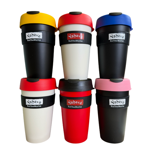 Six reusable travel tumbler cups arranged in two rows of three on a plain white background. The cups have black bodies with lids in yellow, red, blue, red, black, and pink, and each cup has a black band with  brand logo.