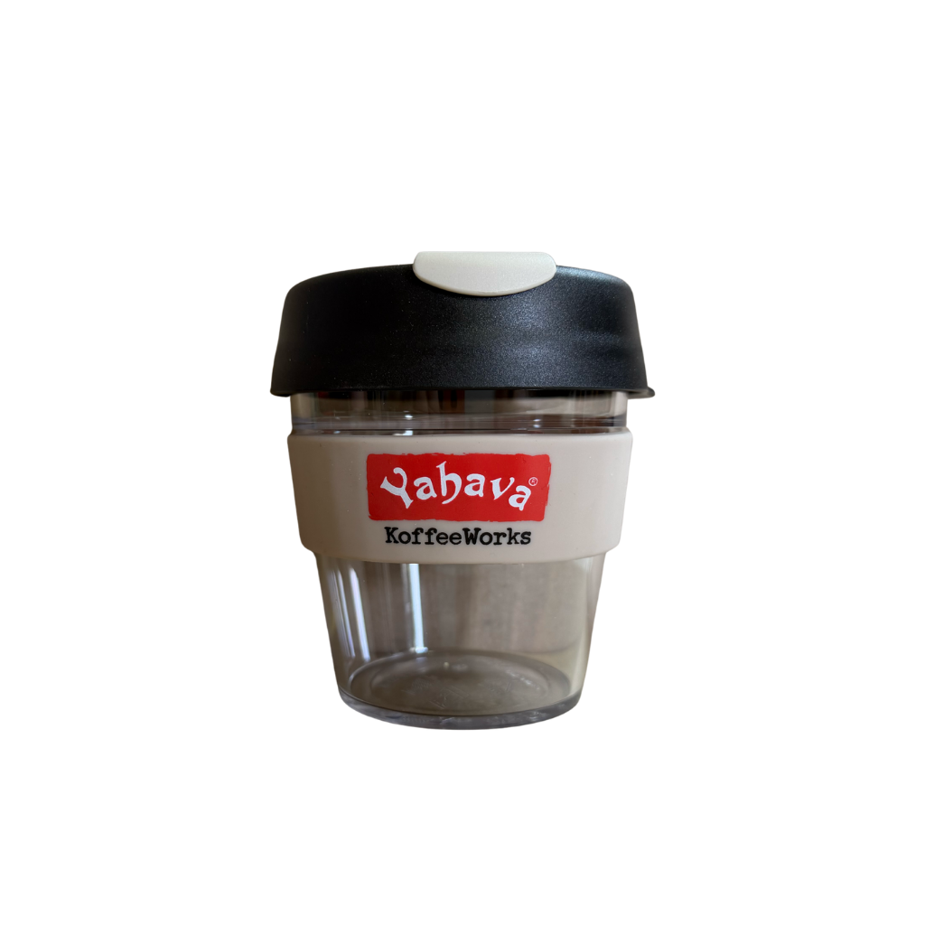 A reusable travel coffee cup with a black lid, clear plastic body, and a beige band featuring a red and white 'Yahava KoffeeWorks' logo, shown on a plain white background.