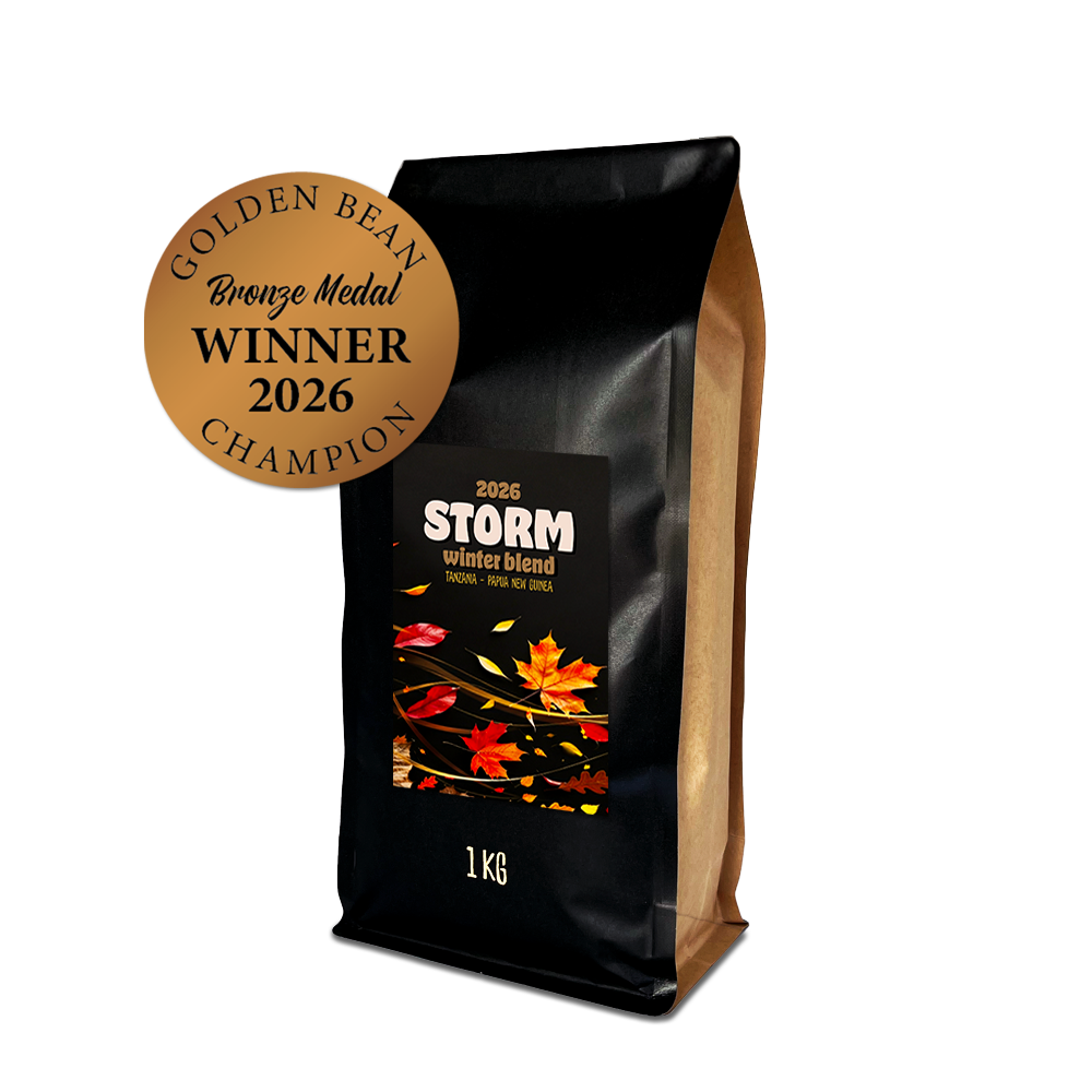 Black coffee bag labeled 'STORM winter blend' with autumn leaf design on a white background with a Golden Bean Bronze Medal Winner 2026 sticker. 