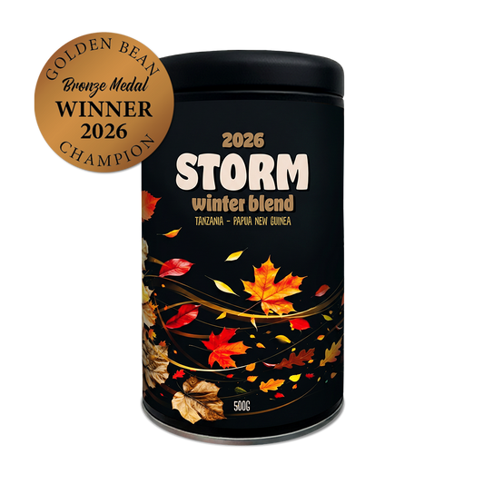 Black container labeled '2026 Storm winter blend' with autumn leaf design on a white background. Golden Bean Bronze Medal Winner 2026 label