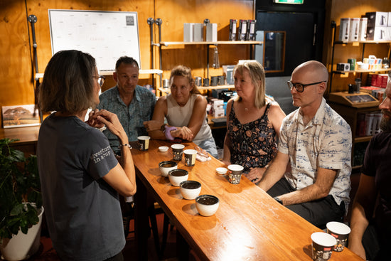 customers learning about coffee, how it is grown, roasted and how to drink. coffee cups and cupping bowls.
