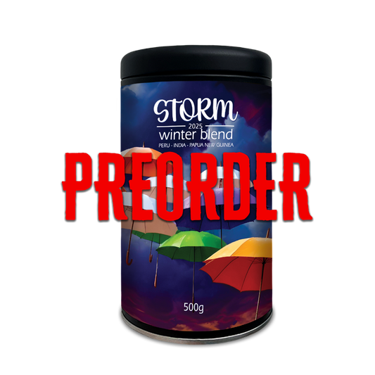 A reusable canister of STORM winter blend coffee with a label featuring multi-coloured umbrellas. The word 'PREORDER' is prominently displayed in the foreground.